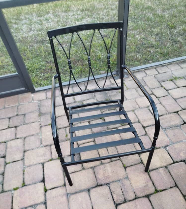 Black metal outdoor chair beside a wall